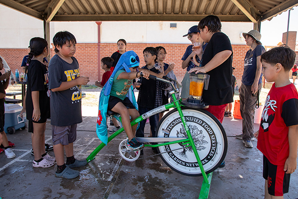 A boy pedals a bike to make smoothies for his classmates