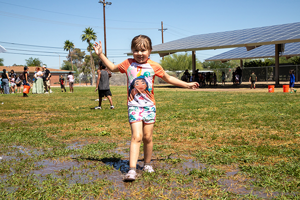 A girl runs through the muddy field
