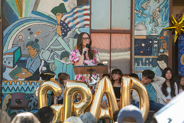 A woman speaks into a microphone during the promotion ceremony
