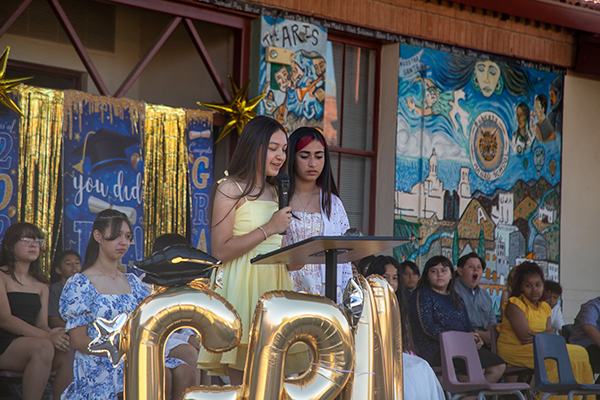 Two girls stand at the podium to speak